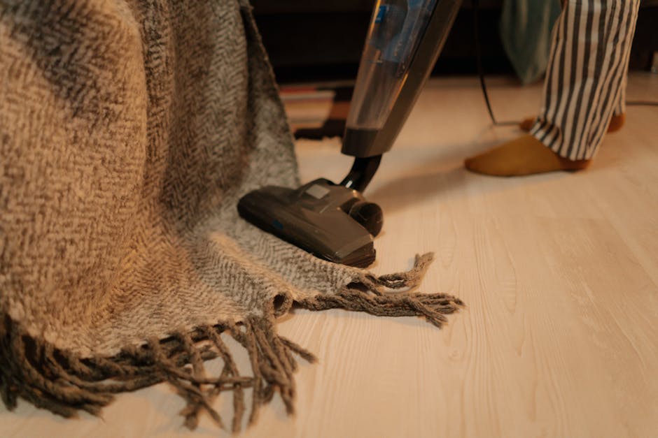Een persoon die voorzichtig verfresten van een houten vloer verwijdert met een geschikt schoonmaakmiddel.